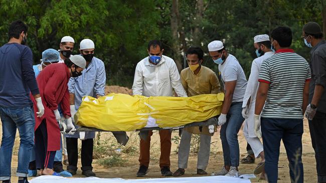 Relatives and friends carry the body of a COVID-19 victim during the burial at a graveyard in New Delhi on Monday. Picture: AFP