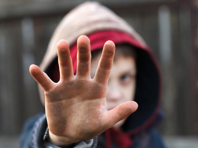 dramatic portrait of a little homeless boy, dirty hand, poverty, city, street. iStock Image