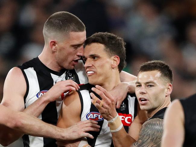 MELBOURNE, AUSTRALIA - SEPTEMBER 03: Ash Johnson of the Magpies celebrates a goal with Darcy Cameron and Jamie Elliott of the Magpies during the 2022 AFL First Qualifying Final match between the Geelong Cats and the Collingwood Magpies at the Melbourne Cricket Ground on September 3, 2022 in Melbourne, Australia. (Photo by Dylan Burns/AFL Photos via Getty Images)