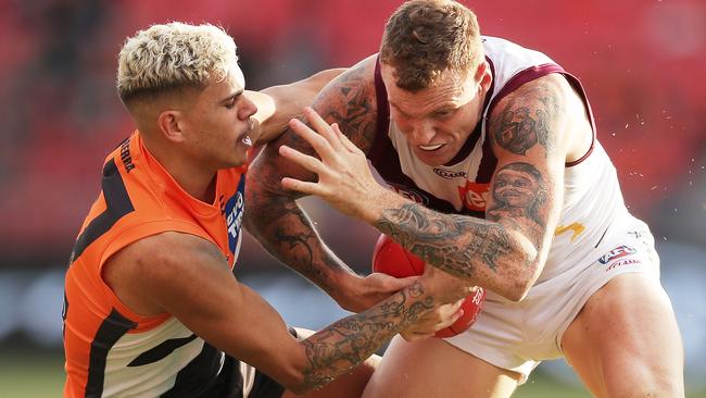 Mitch Robinson brushes off a tackle attempt from GWS Giants’ Bobby Hill.