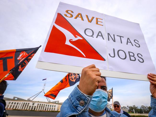 CANBERRA, AUSTRALIA - SEPTEMBER 3: A protester wearing a face mask holds a placard as they attend a rally at Parliament House on September 3, 2020 in Canberra, Australia. Qantas announced plans in August to cut a further 2,500 jobs at the national airline in August, attracting calls for Prime Minister Scott Morrison to intervene.  (Photo by David Gray/Getty Images)