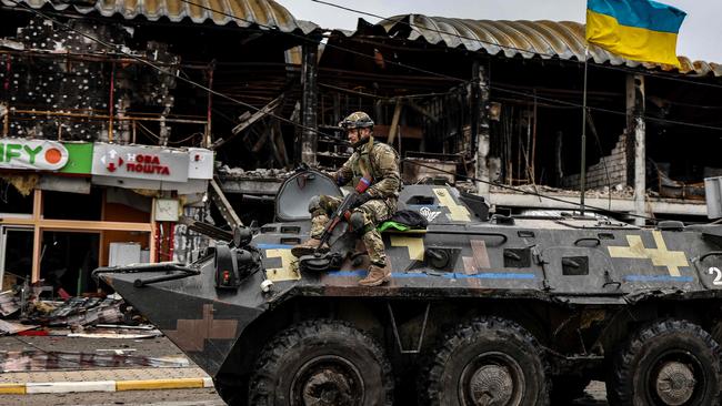 An Ukranian soldier patrols in an armoured vehicle a street in Bucha, northwest of Kyiv. Picture: AFP