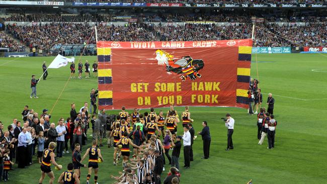 The Crows cheer squad re-creates the banner from Adelaide's first game in 1991 "Get some Hawk on your fork" on the 20th anniversary.