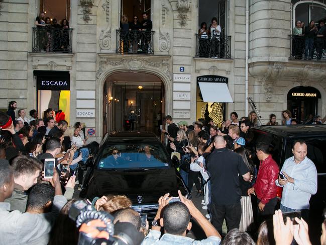 The crowd surrounds Kim Kardashian West, Kourtney Kardashian and Kanye West as they leave the ‘Givenchy’ office on September 29, 2016 in Paris, France. Picture: Getty