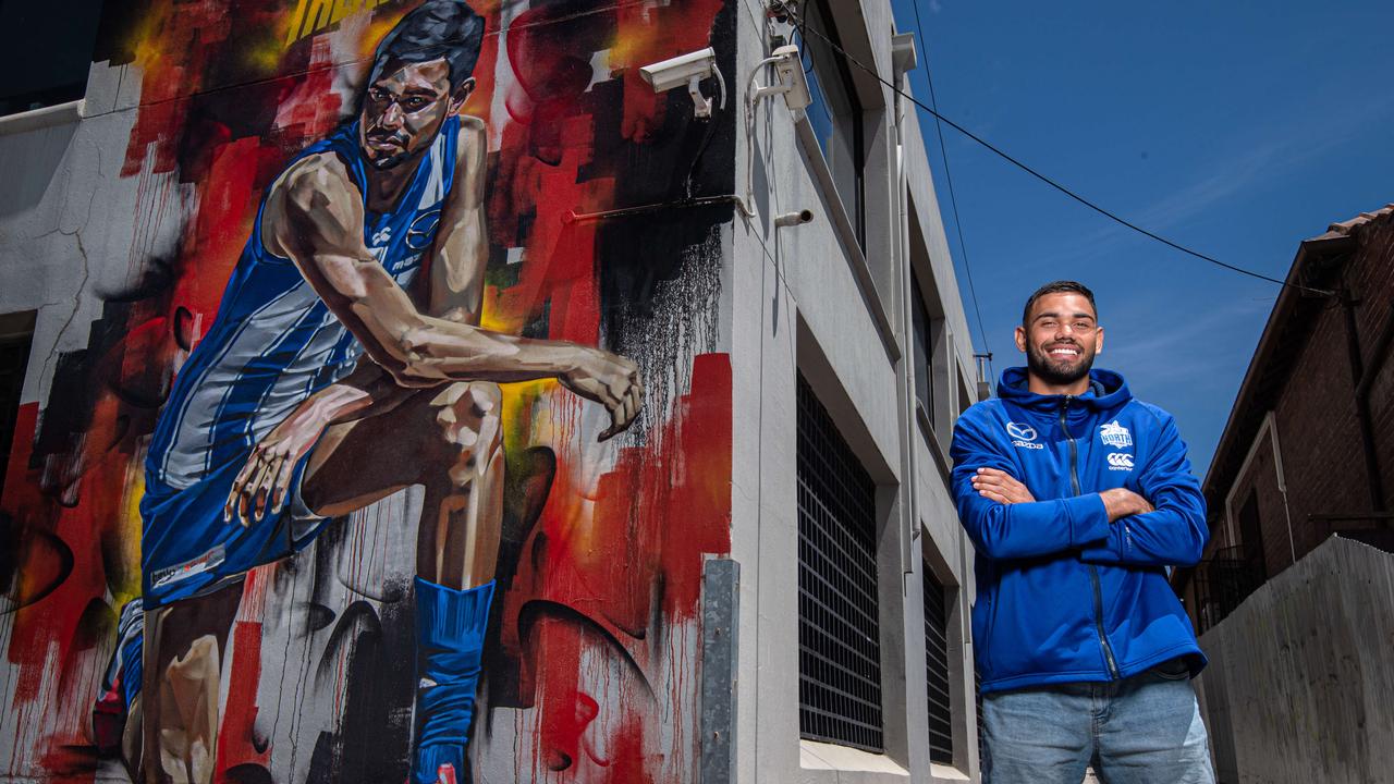 North Melbourne star Tarryn Thomas in front of the Black Lives Matter Mural of him at the corner of Curzon St and Victoria St North Melbourne. Picture: Jason Edwards