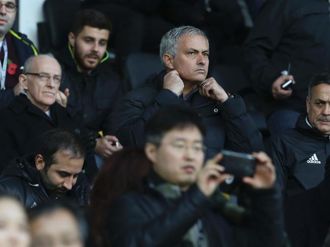 Manchester United's Portuguese manager Jose Mourinho (C) sits in the stands.