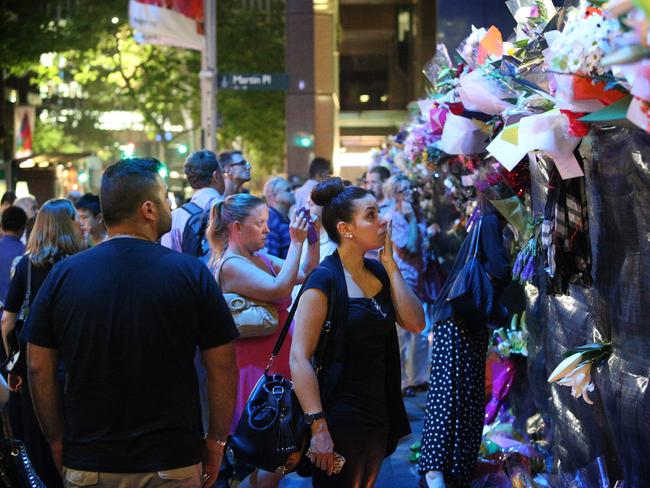 Mourners gather near the siege that took place at the Lindt Cafe.