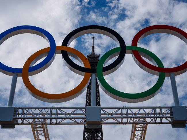 This photograph shows the Olympic Rings displayed at the construction site of the Eiffel Tower Stadium for the upcoming Paris 2024 Olympics and Paralympic Games which will host the Beach Volleyball and men's Blind Football competitions, at the Champ-De-Mars in Paris on July 10, 2024. The Champ de Mars and the Trocadero, located on either side of the Eiffel Tower, will host several events of the Paris Olympic and Paralympic Games, on July 10, 2024. (Photo by Dimitar DILKOFF / AFP)