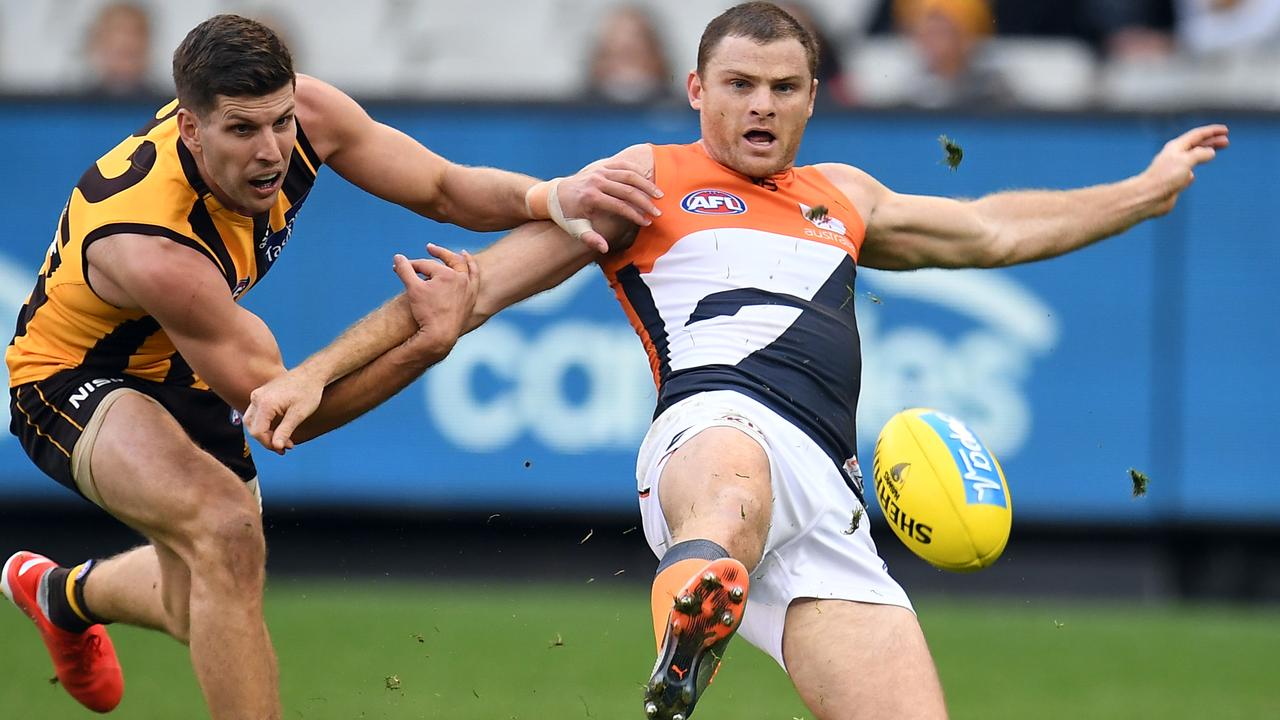 Heath Shaw of the Giants gets another kick away against the Hawks