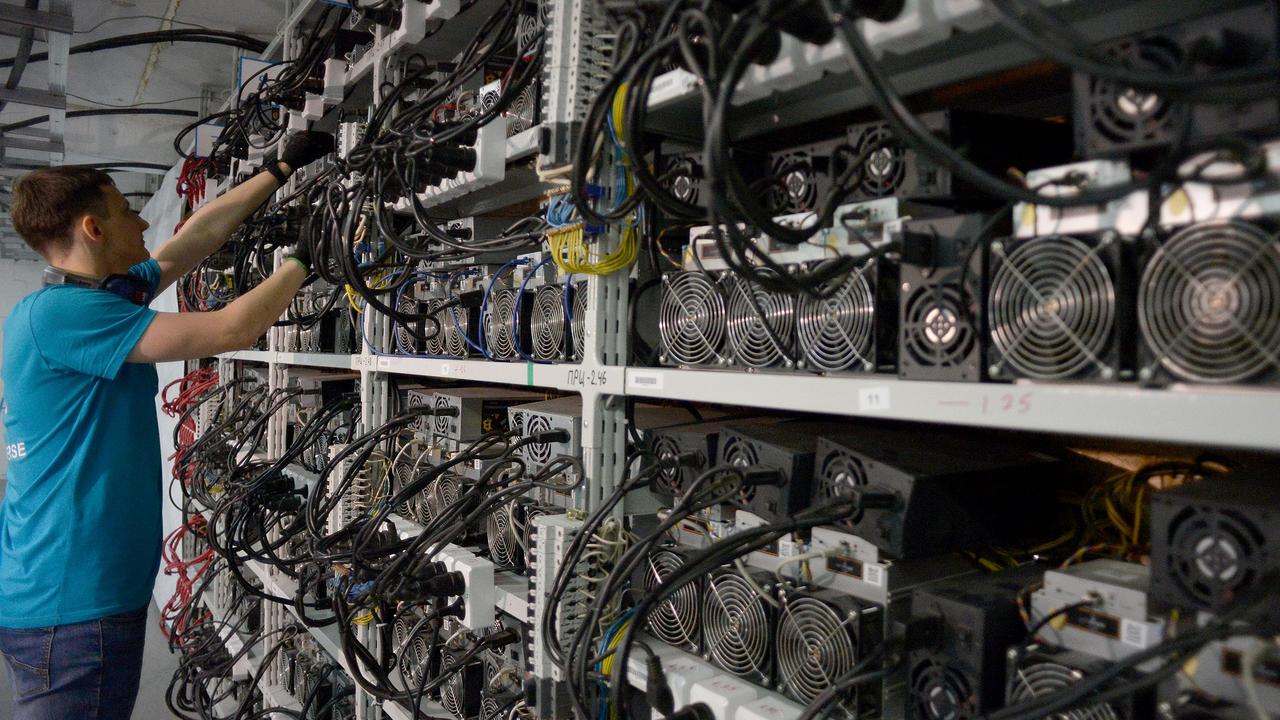 An employee inspects machines for the production of bitcoins.