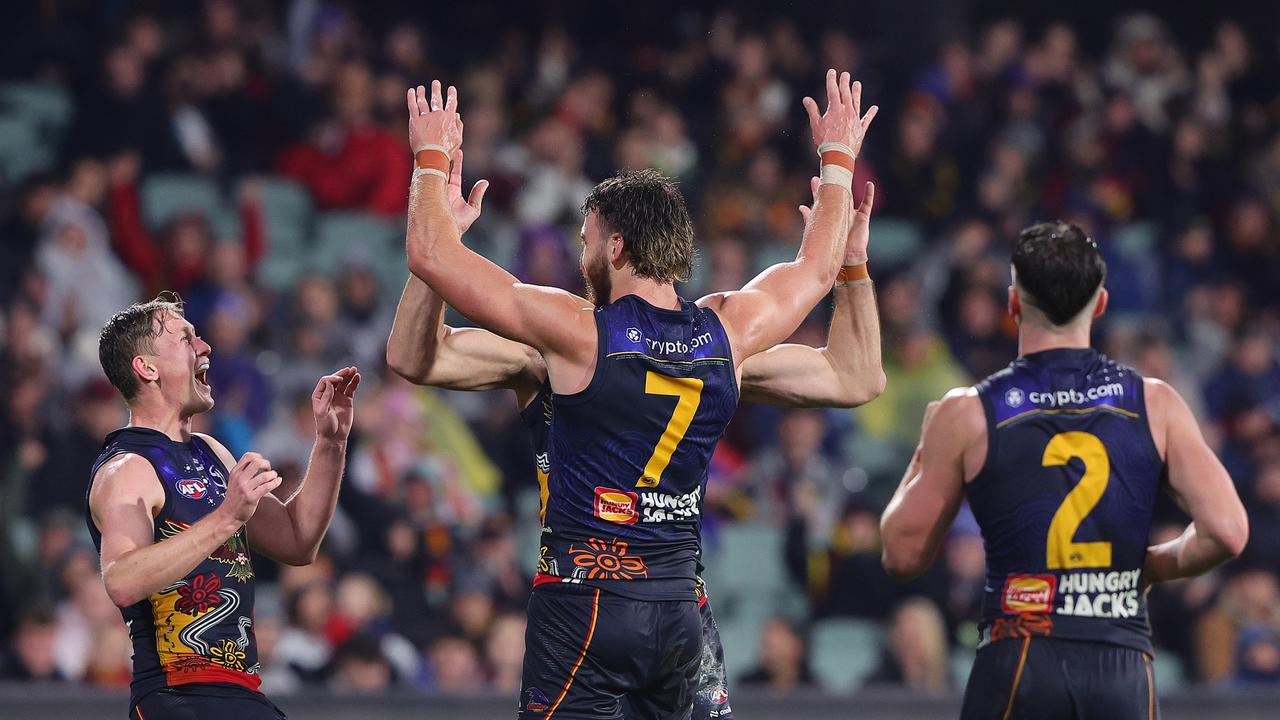 ADELAIDE, AUSTRALIA – JULY 13: Riley Thilthorpe of the Crows gets his 2nd goal celebrating with Taylor Walker and Brayden Cook during the 2024 AFL Round 18 match between the Adelaide Crows and the St Kilda Saints at Adelaide Oval on July 13, 2024 in Adelaide, Australia. (Photo by Sarah Reed/AFL Photos via Getty Images)