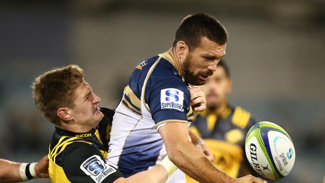 Chris Alcock of the Brumbies loses the ball in a tackle by Jordie Barrett of the Hurricanes.