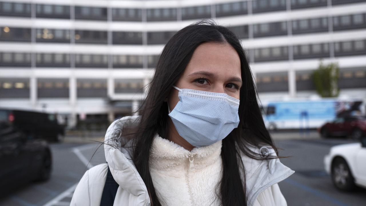 A nurse in front of the medical facility she works at in New York.