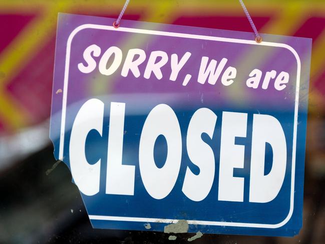 A closed sign outside a shop entrance is seen in the normally-busy central business district (CBD) after the Level 4 lockdown came into force, in Wellington on March 26, 2020. - New Zealand at midnight on March 26 imposed a four-week lockdown in a bid to smother coronavirus infection rates and avoid the mass fatalities seen elsewhere in the world. (Photo by Marty MELVILLE / AFP)