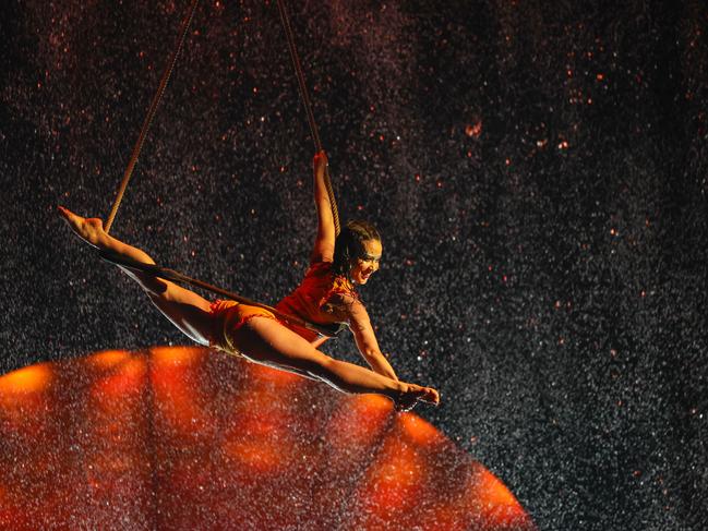 Trapeze artists flex their skill and athleticism in a tropical downpour on stage. Picture: Brendan Beckett