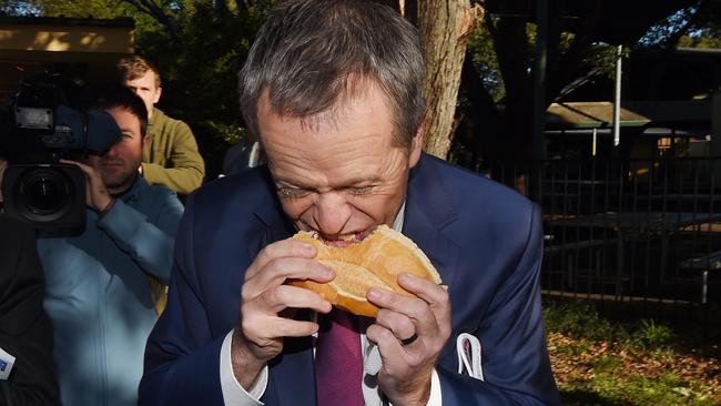 Leader of the Opposition Bill Shorten eats a sausage sandwich at Strathfield North Public School polling booth as part of the 2016 Election Day in Sydney, Saturday, July 2, 2016. (AAP Image/Mick Tsikas) NO ARCHIVING