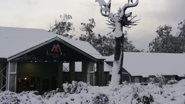 Snow blankets the ground and buildings at Cradle Mountain Hotel