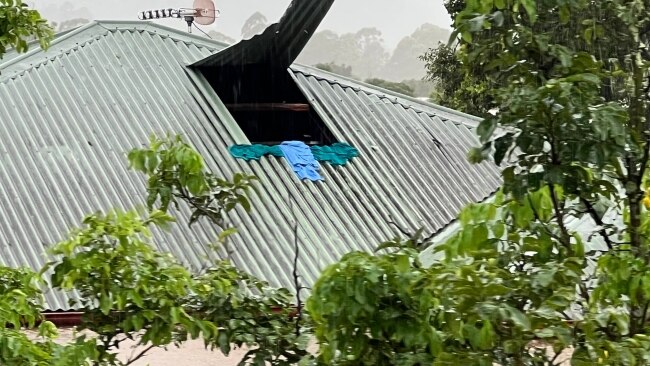 Social media images showed the desperate scramble from residents who were forced to cut a hole in their tin roof to escape rising floodwaters that lapped at ceiling. Picture: Twitter/@worldzonfire