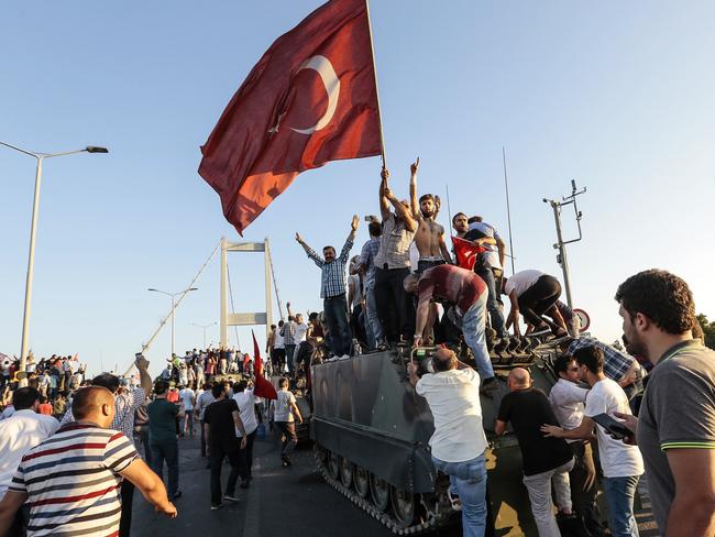 Supporters of Turkish President Recep Tayyip Erdogan wave flags as they capture a Turkish Army APC. Picture: Gokhan Tan/Getty Images