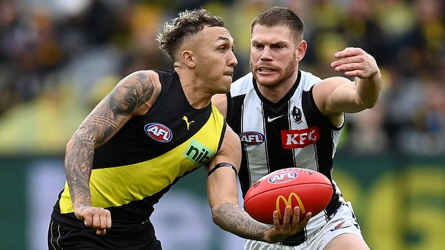 MELBOURNE, AUSTRALIA - MAY 07: Shai Bolton of the Tigers handballs whilst being tackled by Taylor Adams of the Magpies during the round eight AFL match between the Richmond Tigers and the Collingwood Magpies at Melbourne Cricket Ground on May 07, 2022 in Melbourne, Australia. (Photo by Quinn Rooney/Getty Images)