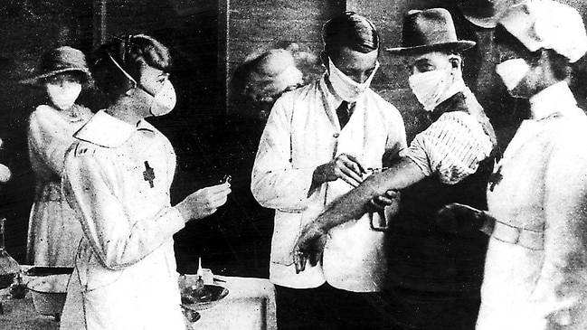 Nurses and doctors wearing protective masks vaccinate patients from Spanish influenza at Hyde Park inoculation depot during 1919 epidemic.