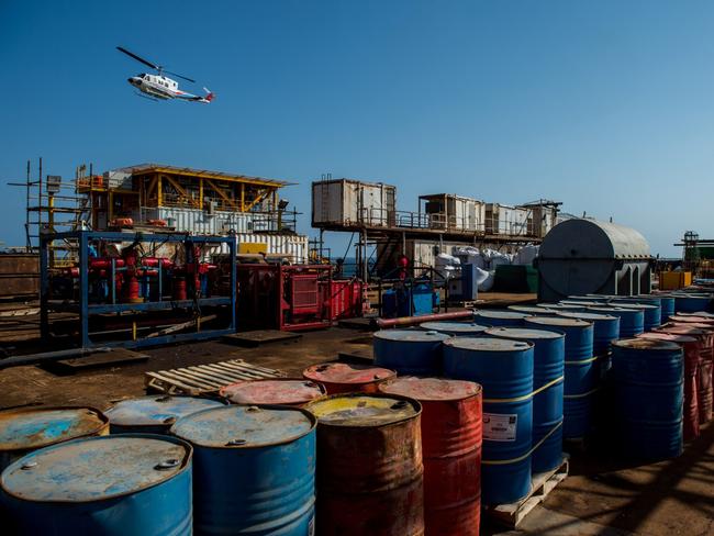 A helicopter flies over oil storage drums aboard an offshore oil platform in the Persian Gulf's Salman Oil Field, operated by the National Iranian Offshore Oil Co., near Lavan island, Iran, on Thursday, Jan. 5. 2017. Nov. 5 is the day when sweeping U.S. sanctions on Iran’s energy and banking sectors go back into effect after Trump’s decision in May to walk away from the six-nation deal with Iran that suspended them. Photographer: Ali Mohammadi/Bloomberg