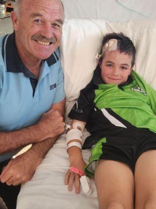 Wally Lewis paid a visit to footy fan Fletcher Campbell after his brain surgery. Picture – contributed.