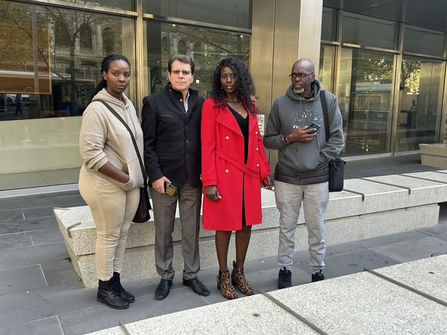 Darrell Chepseba's mother Rose (in red), step father Russell Davidson, second from left, and other family members outside the County Court in Melbourne following the sentencing.