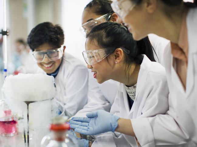 Curious students watching chemical reaction, conducting scientific experiment in laboratory classroom