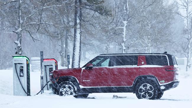 A Rivian truck recharges during a snowstorm on March 3 in Truckee, California. In January’s harsh winter, dozens of Chicago EV owners needed their cars towed after batteries froze at stations. Picture: Getty Images/AFP