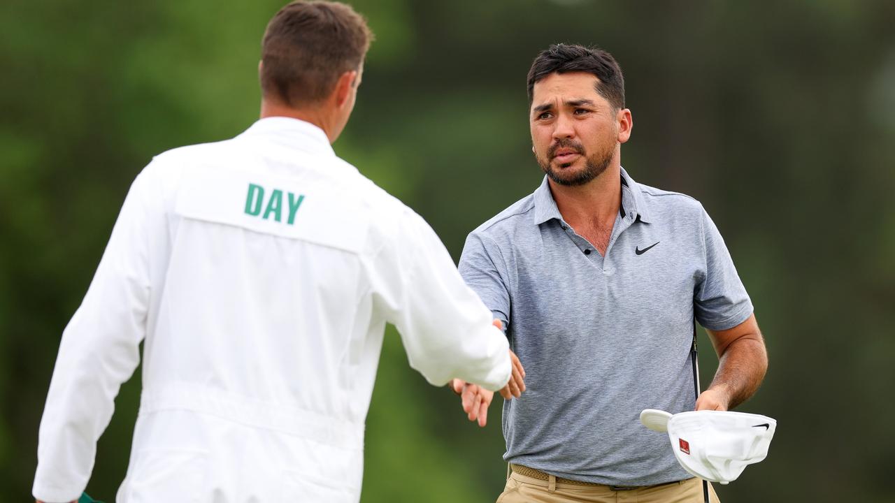 Jason Day shakes hands with his caddie Luke Reardon on the 18th green after shooting -5 on day one at Augusta. Picture: Andrew Redington/Getty Images