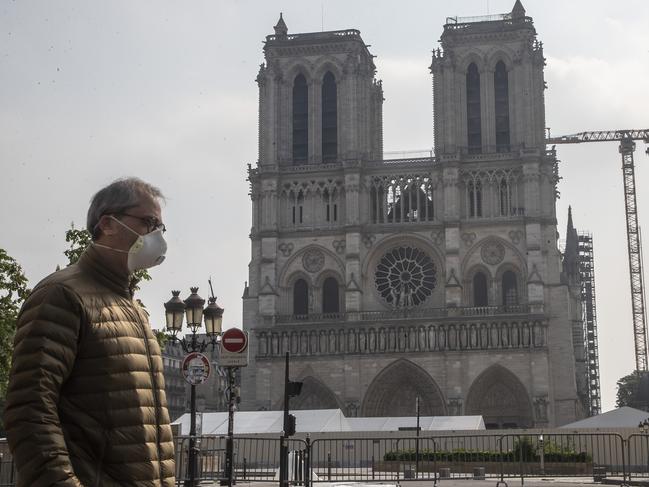 A man walks past the Notre Dame cathedral in Paris, as Emmanuel Macron extended the country’s lockdown. Picture: AP