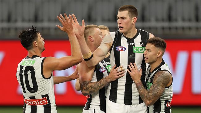 PERTH, AUSTRALIA – OCTOBER 03: Mason Cox of the Magpies celebrates a goal with Scott Pendlebury and Jamie Elliott during the AFL First Elimination Final match between the West Coast Eagles and the Collingwood Magpies at Optus Stadium on October 03, 2020 in Perth, Australia. (Photo by Paul Kane/Getty Images)