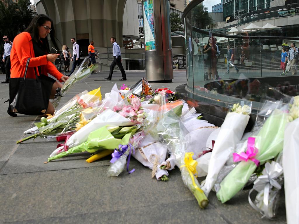 People lay flowers at a memorial in Martin place after the Lindt cafe siege. Picture: John Grainger