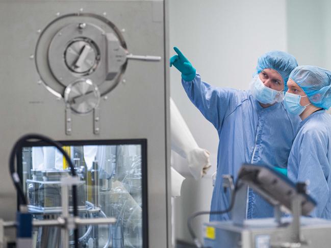 Employees in protective gear work at the aseptic filling section at the AstraZeneca facility in Stockholm, Sweden, Picture: AFP