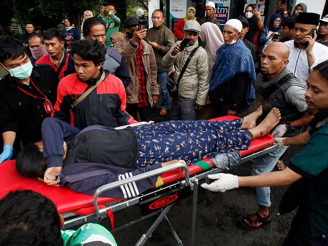 People evacuate a wounded woman on a stretcher following a landslide triggered by earthquake in Cianjur. Picture: AFP.