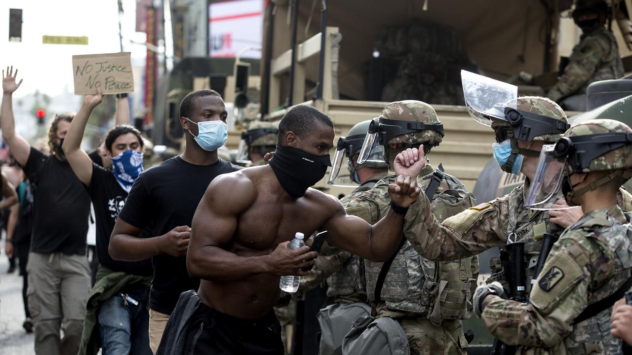 Demonstrators greet members of the National Guard as they march along Hollywood Boulevard, Tuesday in the Hollywood section of Los Angeles. Picture: AP/Ringo HW Chiu