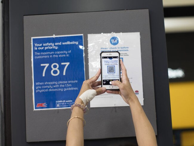 A customer scans a QR code to check in before entering a KMart store, operated by Wesfarmers Ltd., in Sydney, Australia, on Thursday, Feb. 18, 2021. Wesfarmers is scheduled to release earnings today. Photographer: Brent Lewin/Bloomberg via Getty Images