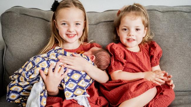 Paige, now 7, and Imogen, now 3, hold their little brother Darcy. Picture: Upon Our Days Photography