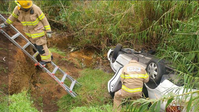 CFS crews inspecting the silver Toyota sedan, which flipped into the creek bed. Picture: Colin James