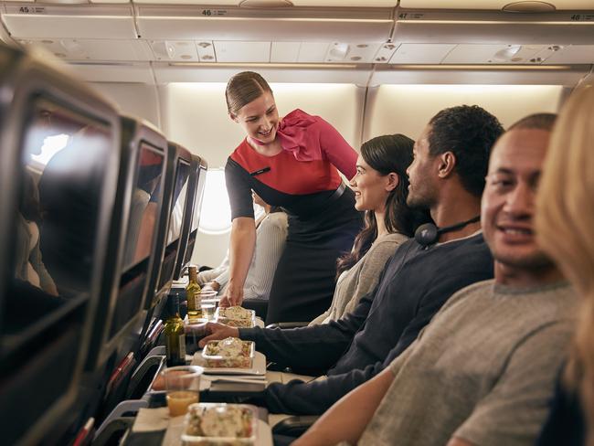 From Jan 20, Qantas will be offering direct seasonal flights from Sydney to Sapporo’s New Chitose Airport, to help make it easier for travellers to reach Hokkaido’s world-class ski resorts on Japan's northernmost island. Picture: Supplied/Qantas.    Inflight economy cabin passengers are getting food served in Qantas A330