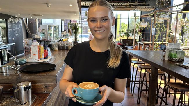 Emjays Birtinya staff member Lily Wooldrage serves a customer a coffee.