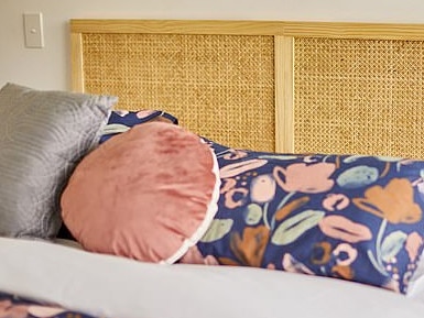 The collection has been developed and curated by the retailer's in-house design team and buying team in Melbourne (pictured: rattan bed head, cushions and doona cover set). Picture: Supplied/Kmart