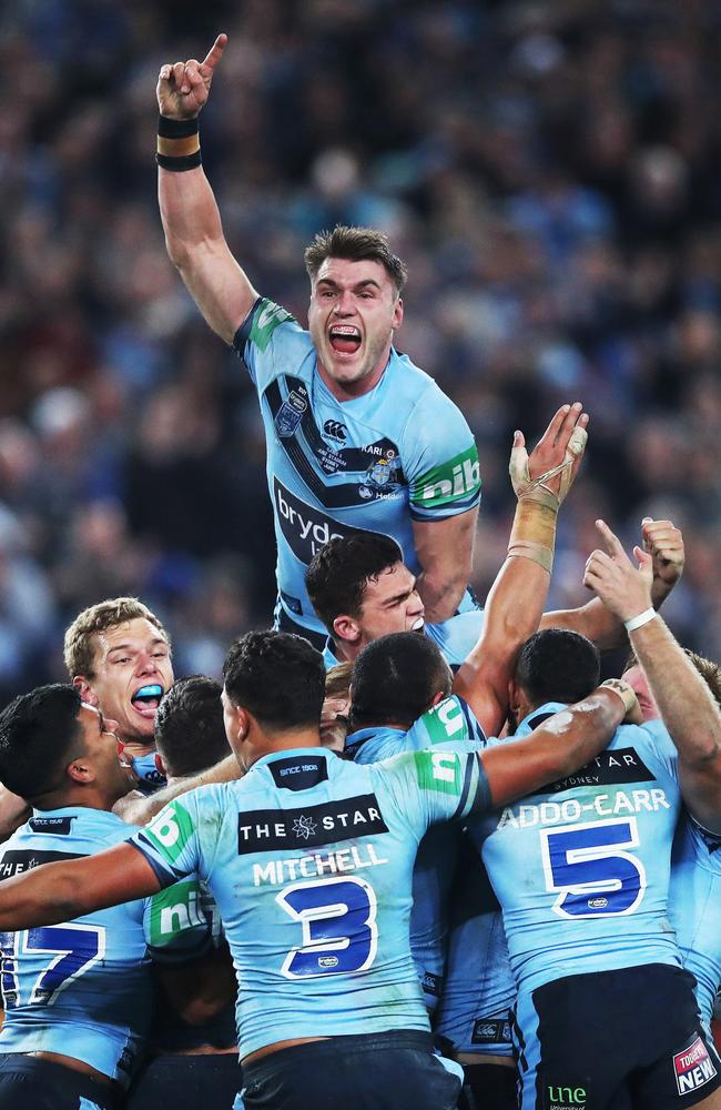 Angus Crichton leaps on to teammates as the Blues celebrate after the NSW defeated Queensland Maroons in Game 2 of State of Series at ANZ Stadium, Sydney. Picture. Phil Hillyard