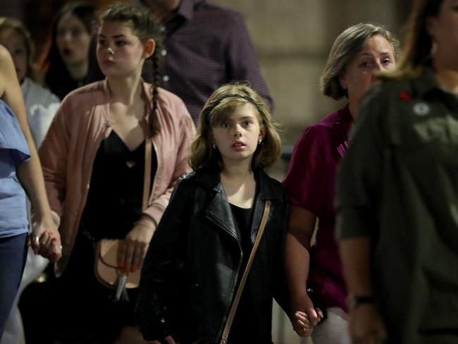 Police escort members of the public from the Manchester Arena as they’re reunited with their parents. Picture: Getty