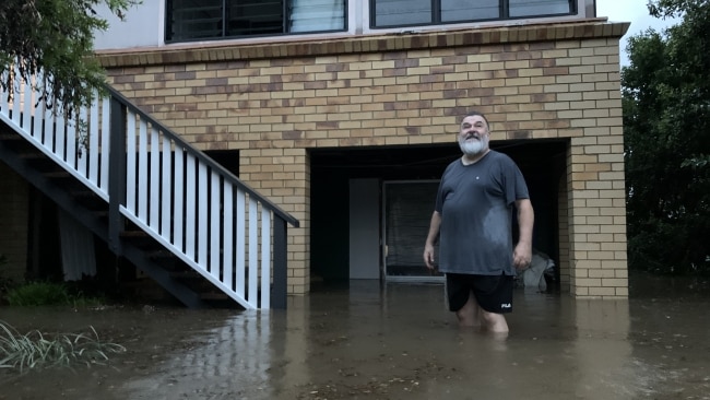 Lismore resident Michael Moynihan watches the floodwaters rise outside his home. Picture: Stuart Cumming