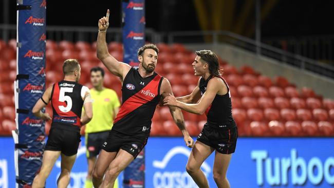 GOLD COAST, AUSTRALIA - JULY 25: Cale Hooker of the Bombers celebrates with teammates after kicking a goal during the round 19 AFL match between Essendon Bombers and Greater Western Sydney Giants at Metricon Stadium on July 25, 2021 in Gold Coast, Australia. (Photo by Albert Perez/AFL Photos/via Getty Images)