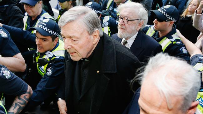 Cardinal George Pell walks with a heavy police guard to the Melbourne Magistrates' Court in July 2017. Picture: Getty