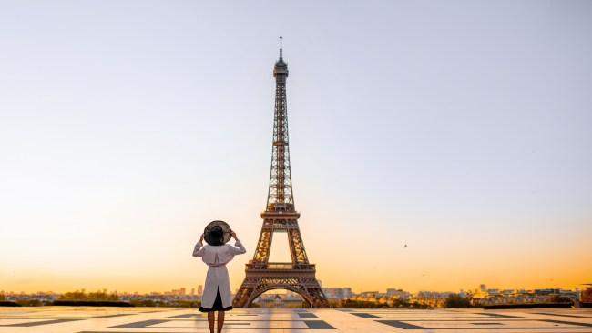 Famous square with great view on the Eiffel tower and woman standing back enjoying the view in Paris