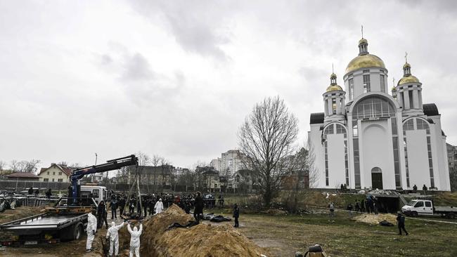 Ukrainian investigators exhume bodies from a mass grave in the gardens of the St Andrew church in the town of Bucha, northwest of Kyiv. Picture: Genya SAVILOV / AFP